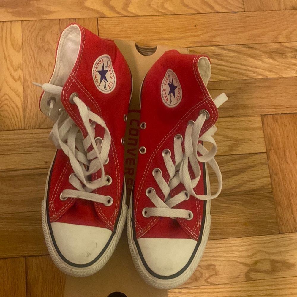 Red Converse high top sneakers.